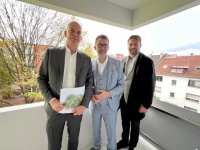 Mehrere Personen stehen auf einem überdachten Balkon