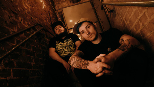 Bandfoto Romans Nailed It 2 Männer sitzen auf einer Treppe