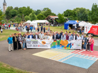 Eine Gruppe Menschen hält ein Banner mit einem Schriftzugdarauf.