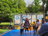 Ein Mann und eine Frau stehen auf den Sprossen zweier Leitern,  die von Kindern gestützt werden.