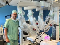 Ein Mann steht in einem Operationssaal mit einem futuristischen Behandlungsgerät