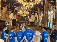 Sechs Sportler in ihren Trikos stehen in einem Festsaal vor einem Amtsträger