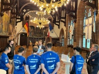 Sechs Sportler in ihren Trikos stehen in einem Festsaal vor einem Amtsträger