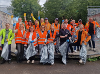 Menschen in Warnwesten mit Müllbeuteln