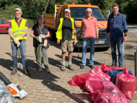 Menschen mit Warnwesten und Müllsäcken