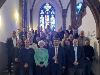 Eine Gruppe Menschen steht auf einer großen Stufe mit einem roten Teppich