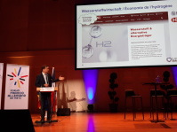 Ein Mann steht auf einer Bühne und hält einen Vortrag