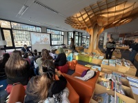 Ein Mann liest Kindern aus einem Buch vor.