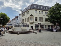 Ein weißer Brunnen in einer belebten Fußgängerzone